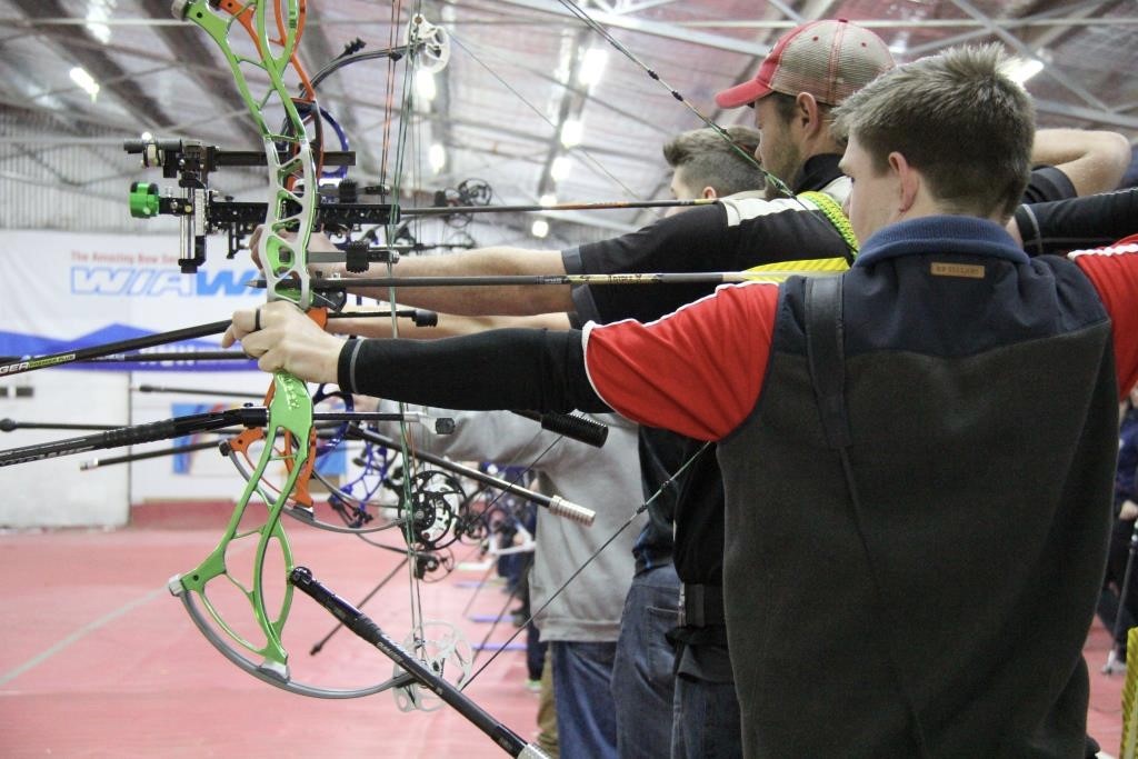 Image of people with bow and arrows in an archery facility