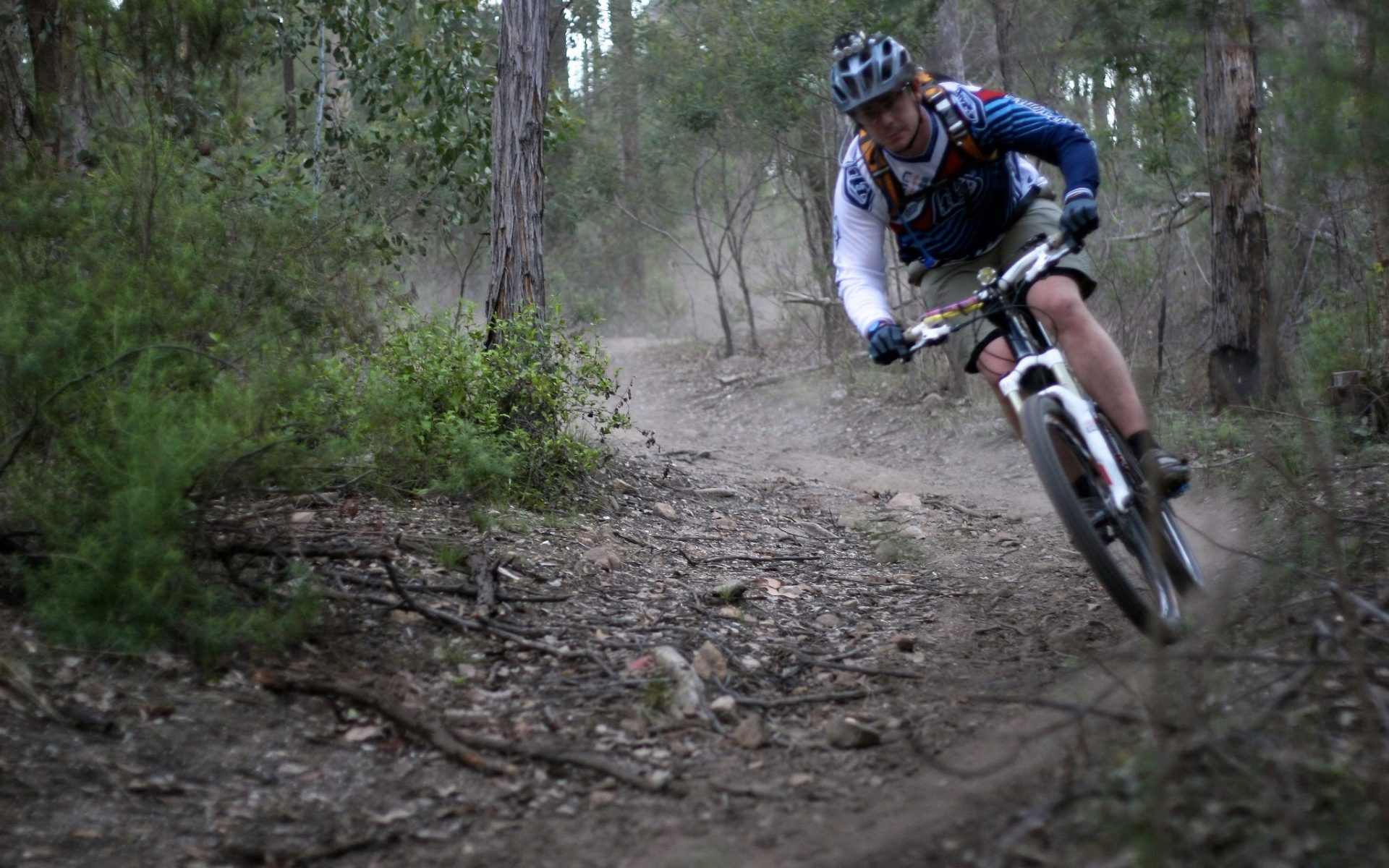 Image of a boy on a mountain bike riding down a mountain bike track Image of a boy on a mountain bike riding down a mountain bike track