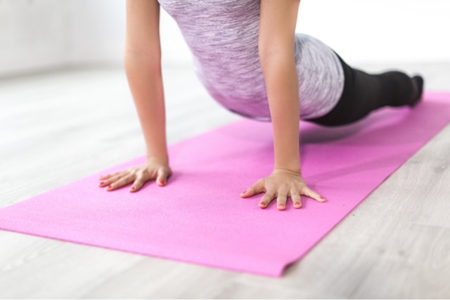 Female exercising body balance on mat