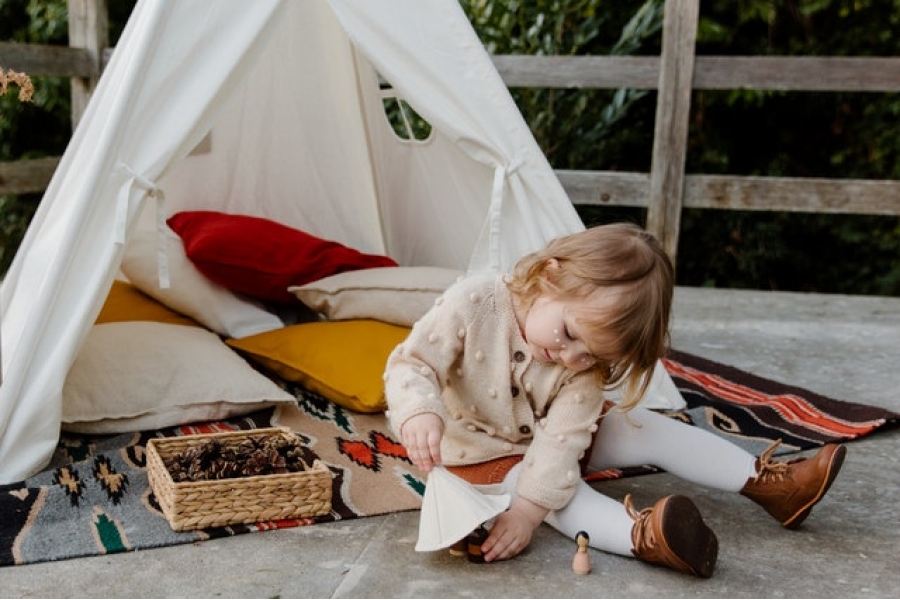 photo-of-kid-wearing-knitted-sweater Kid playing outside her tent on a picnic mat