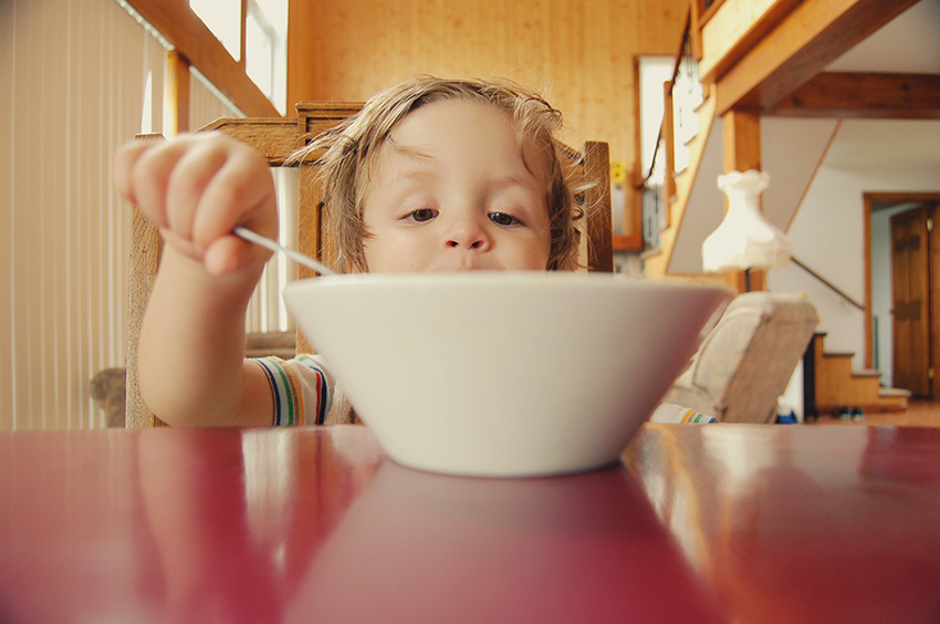 Toddler feeding himself from a large bowl Toddler feeding himself from a large bowl