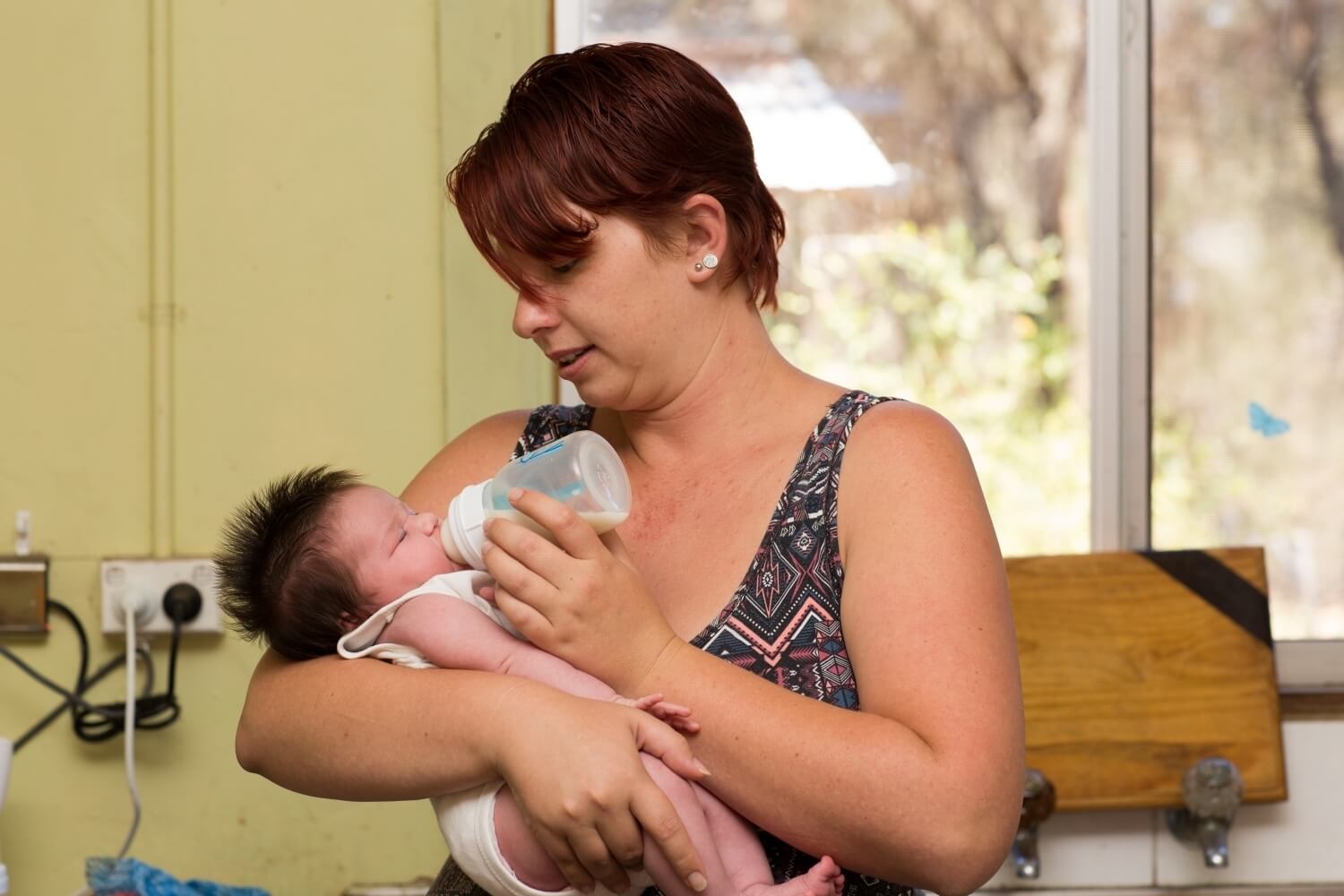 A mother bottle feeding her newborn baby