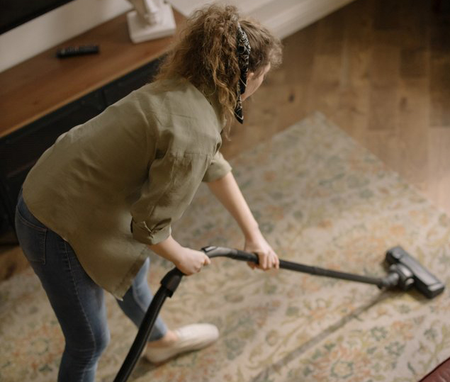 birds-eye view of a women vacuuming a rug birds-eye view of a women vacuuming a rug
