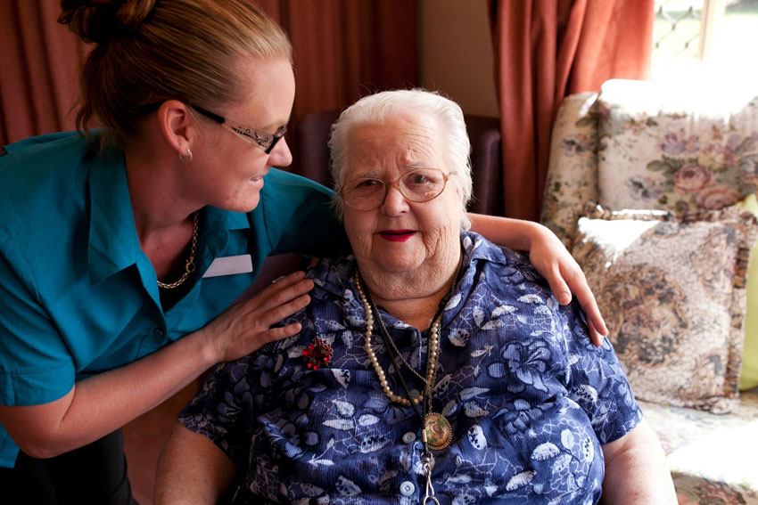 A nurse hugs the person she is caring for.