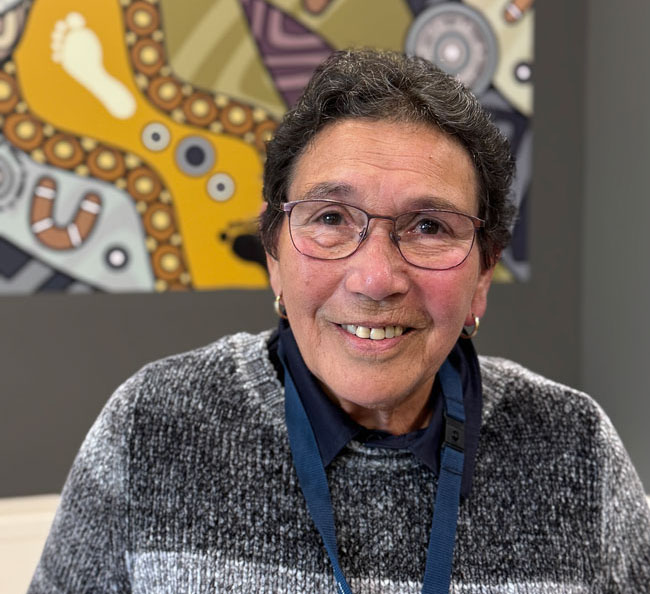 First Nations Liaison Officer Cheryl Drayton A woman stands in front of the camera, smiling.