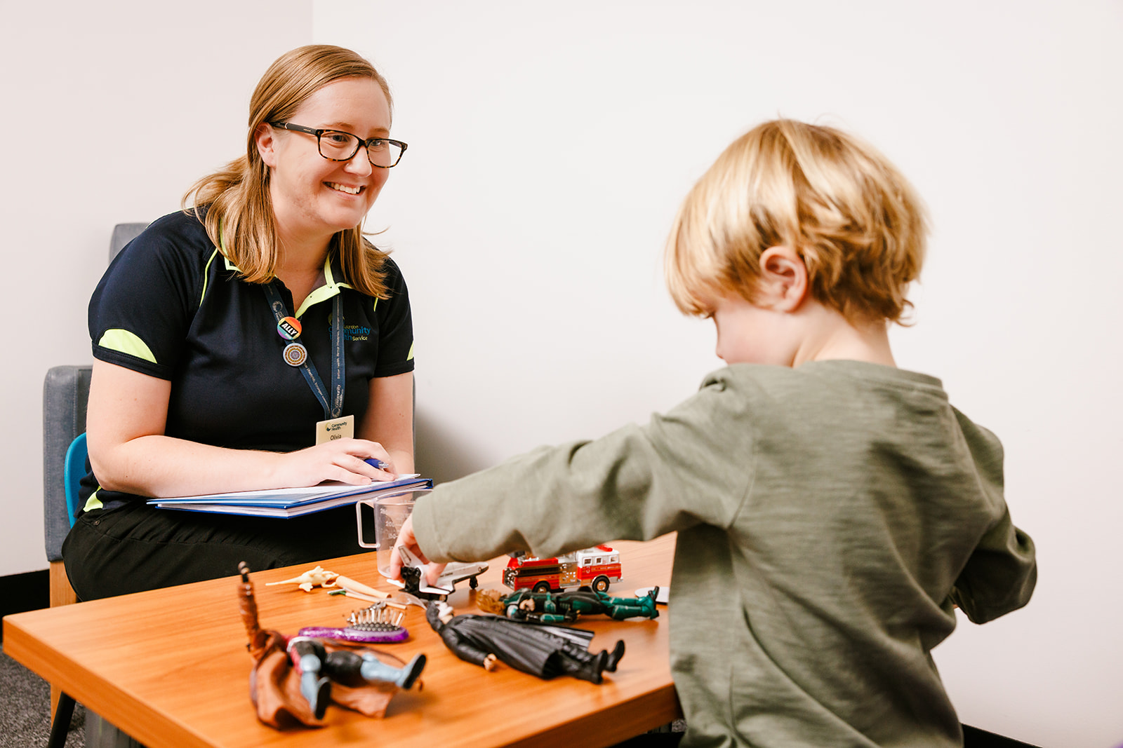 Latrobe Community Health allied health assistant sitting with small child playing with toys