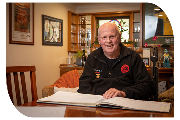 Older man sitting in dining room at home receiving support at home through in-home aged care services from Latrobe Community Health Services.